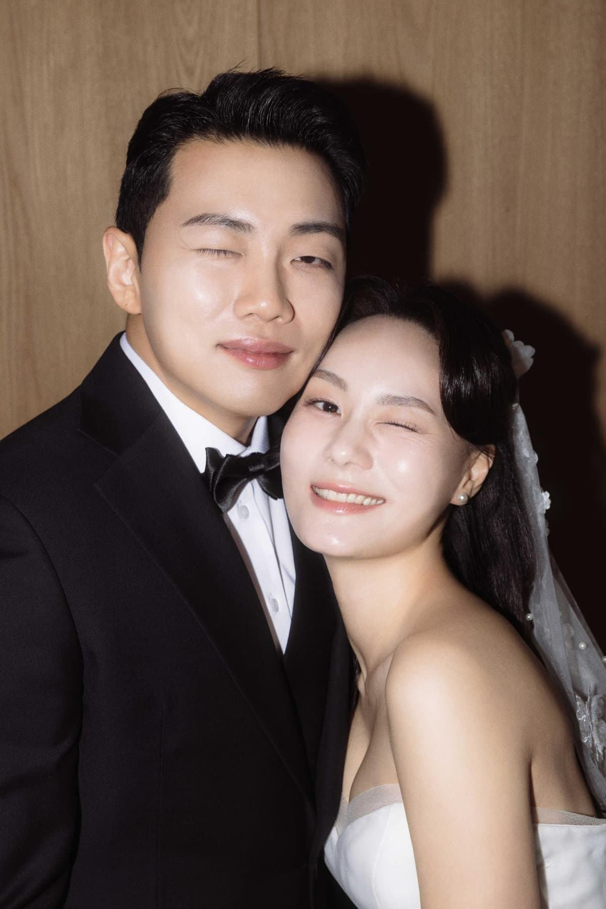 우드톤 벽 앞에서 플래시로 담은 신랑 신부 컷 2