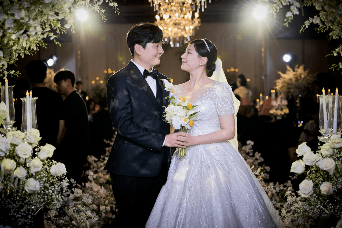 하객들의 휴대폰 불빛 속에서 베일이 날리는 행진 장면 1