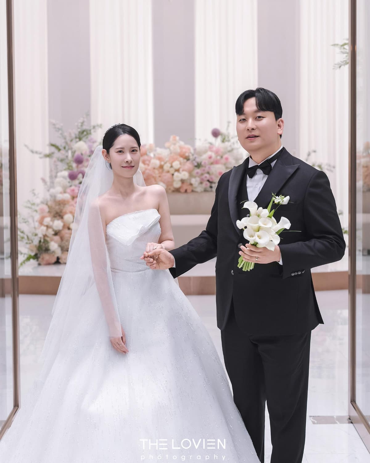 깔끔한 신부대기실과 화이트피치톤 꽃 장식 앞 신부님 2